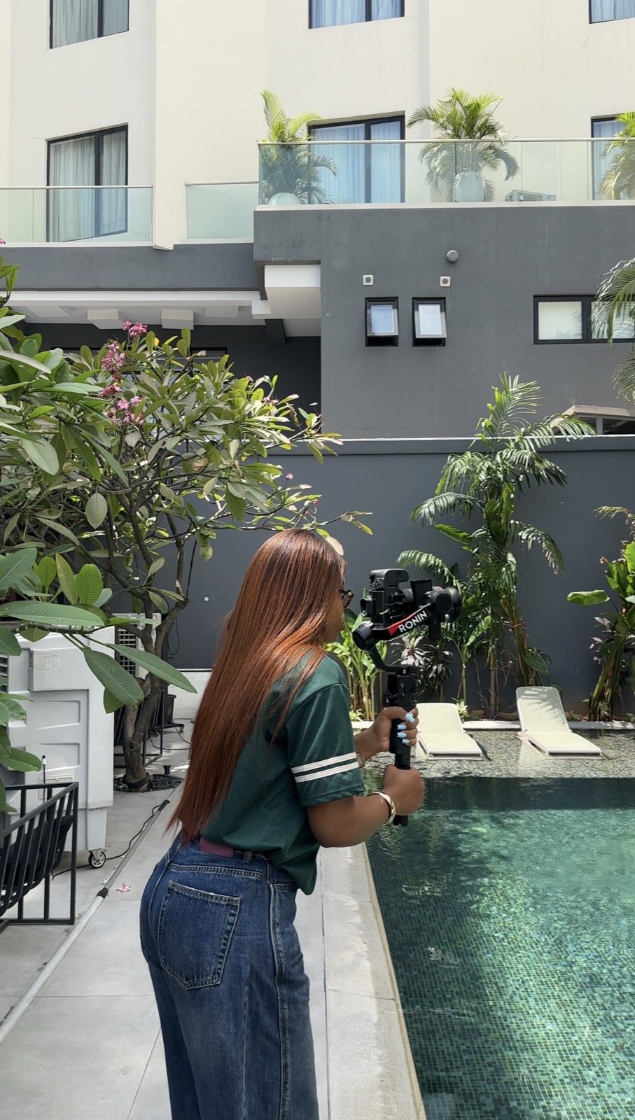 Geraldine holding a camera on a gimbal by a pool